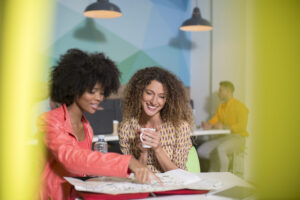 Smiling employees are learning a language in a cafeteria.