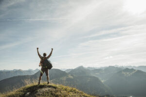 ragazzo festeggia in cima a montagna