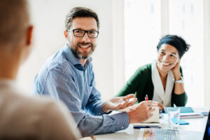 Smiling business people are having a meeting in an office.