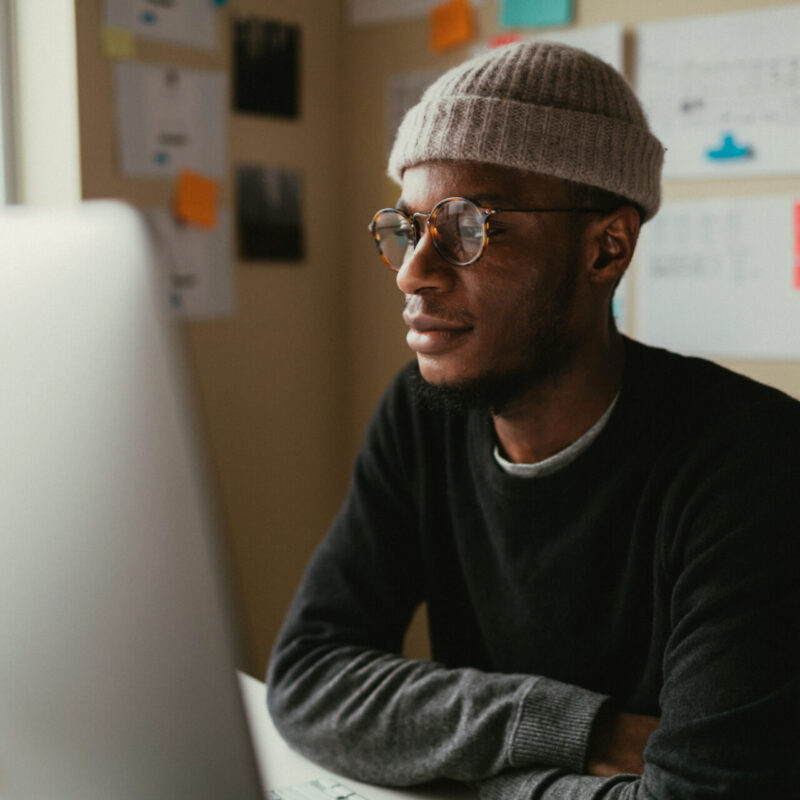 Man is focused on something on his computer monitor.