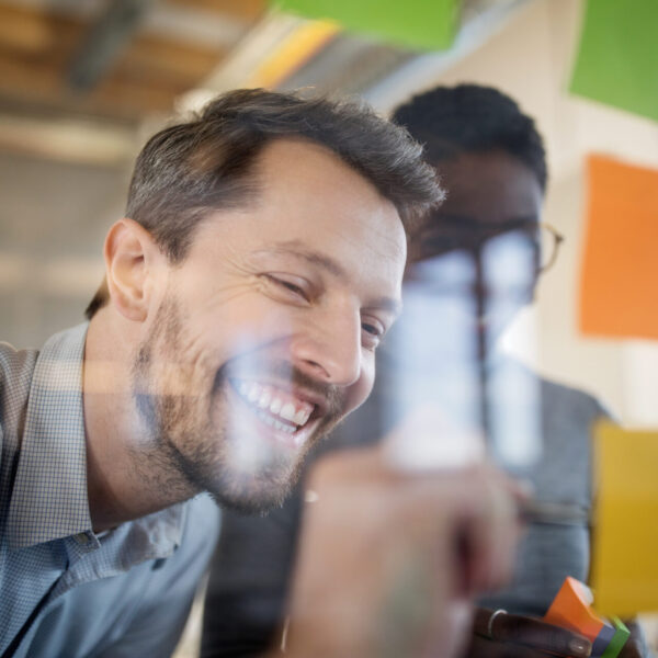 Young business people are smiling and talking freely with their Business English skills in a meeting.